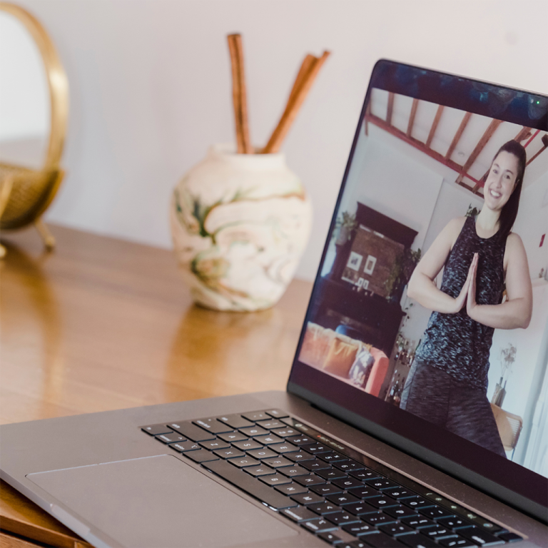 Imagen relacionada a persona haciendo yoga en la laptop en una clase online.